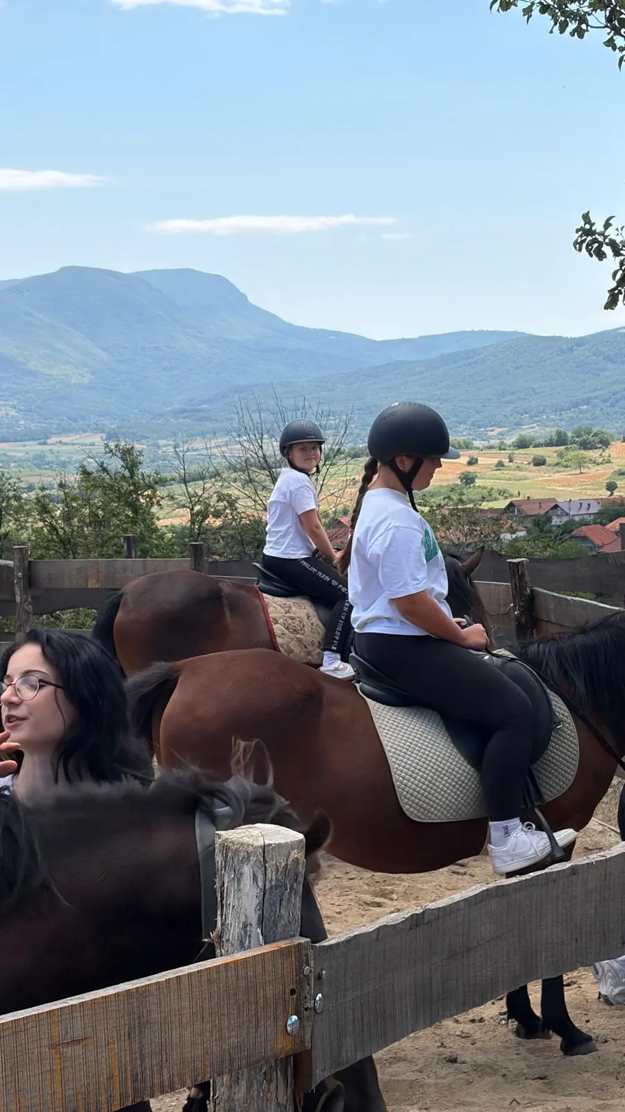 Dve mlade jahačice na konjima sa pogledom na planine